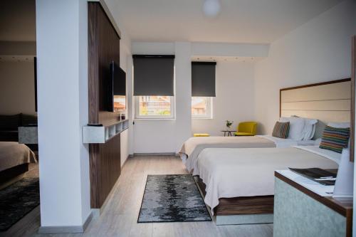 ゲヴゲリヤにあるPaint It Black Hotel & Spaのベッド2台とテレビがあるホテルの部屋