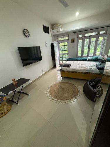 una camera da letto con un letto e una TV a parete di Cozy Little Home - BIR a Bīr