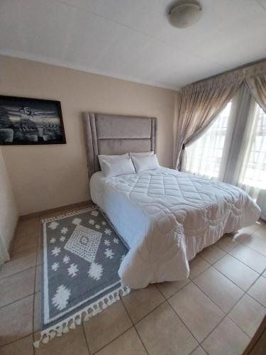 a bedroom with a large bed and a window at Lubsman Apartments in Centurion