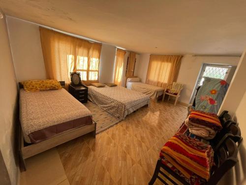 a bedroom with two beds and a living room at Boulemane guest house in Boulmane