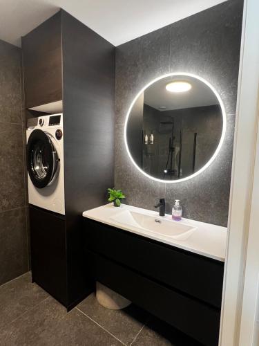 a bathroom with a sink and a washing machine at Newly refurbished apartment in the city center in Verdal