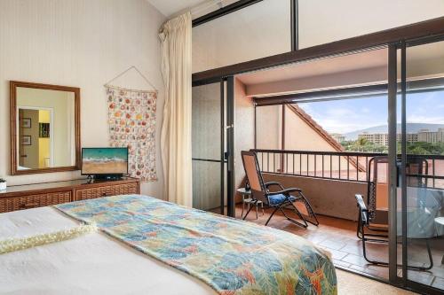 a bedroom with a bed and a balcony with a television at Kaanapali Royal H303 · KRL H303 Spacious 2BD Condo on Maui Golf in Lahaina