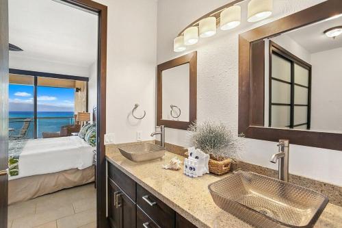a bathroom with two sinks and a bedroom with a bed at Sands of Kahana 354 · SK 354 Updated Maui OceanFront 2BD w Ocean in Kahana