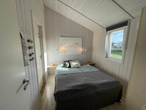 a small bedroom with a bed and a window at Ferienhaus Lykkehus Grömitz in Grömitz