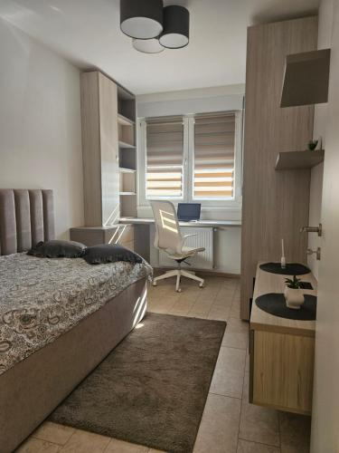 a bedroom with a bed and a desk and a chair at Miss Extra LuX in Mladenovac