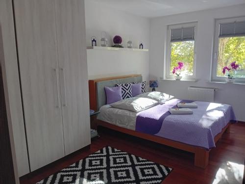 a bedroom with a large bed with purple sheets at Apartament B & S - Free Garage Parking in Szczecin
