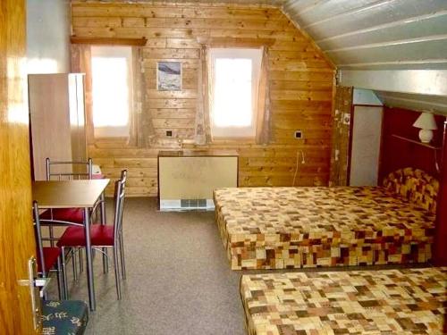 a bedroom with two beds and a table and chairs at Horská chalupa u skiareálu in Horní Malá Úpa