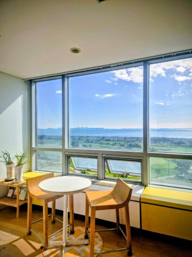 a room with a table and chairs and a large window at Cozy - Sunny Studio in Incheon