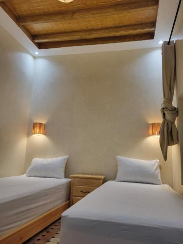 two beds sitting next to each other in a room at Quiet coastal house in the heart of Essaouira in Essaouira