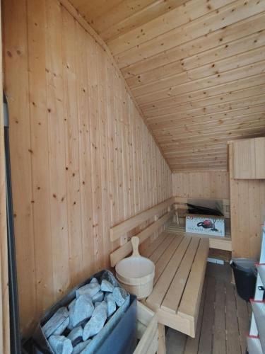 a wooden sauna with a tub and logs in it at Fairytale Cottage in Redenka in Razlog