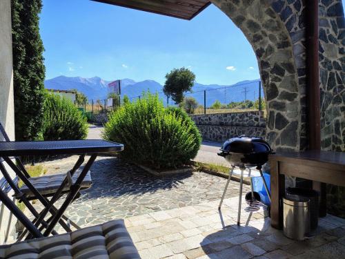 eine Terrasse mit einem Grill und einem Tisch mit Aussicht in der Unterkunft Fairytale Cottage in Redenka in Raslog