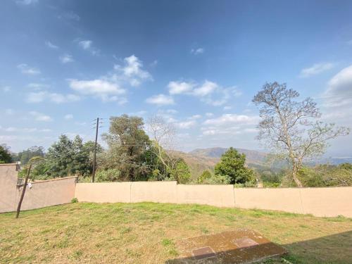 a fence in a field with mountains in the background at Gabriel cottage in Mbabane