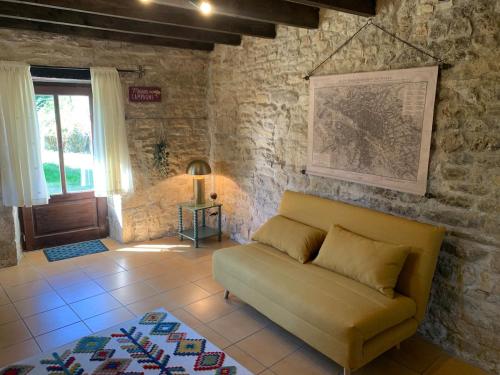 a living room with a couch and a brick wall at Self contained Guest House in Juillé in Juille