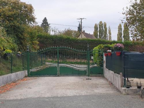 a green gate in a driveway with a fence at Le refuge in Ceton
