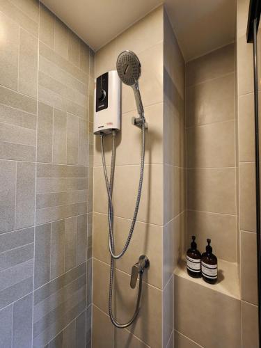 a shower with a shower head in a bathroom at Cozy Palm Haven apartment in Kathu