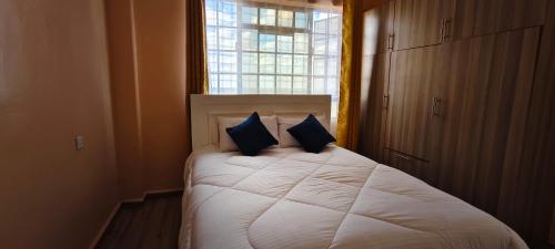 a bedroom with a bed with two pillows and a window at Nyota Haven Stays in Libwezi