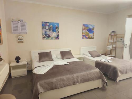 Endi City Centre Room في تيرانا: غرفة نوم بها سريران ولوحات فنية على الحائط