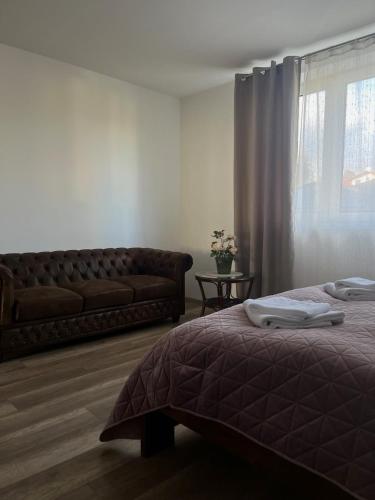 a bedroom with a bed and a couch and a window at Apartmány Starý Blich in Bardejov
