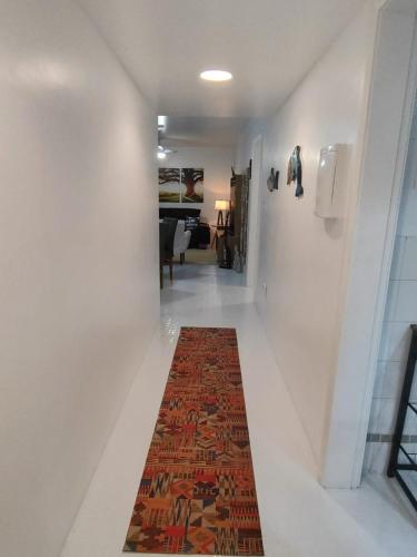 a hallway with a rug on the floor and a hallway with a living room at Apto 3 Dormitórios, 2 Vagas, Completíssimo, Central, próx Mar in Torres
