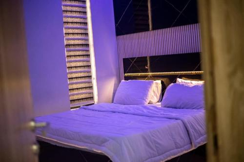 een bed in een kamer met paarse verlichting bij WD exquisite luxury apartment in Lekki