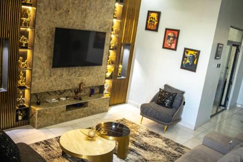 een woonkamer met een televisie, een bank en een stoel bij WD exquisite luxury apartment in Lekki
