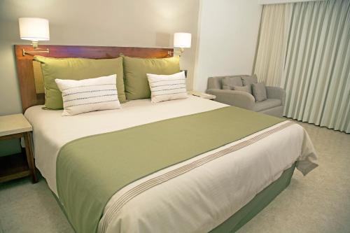 a large bed in a hotel room with a chair at Hotel Terranova in Coatzacoalcos