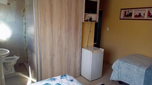 a small bathroom with a refrigerator and a bed at Mountain View Guesthouse in Roodebloem