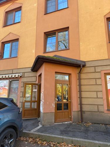 a building with brown doors and a car parked in front at Apartmán u Krakonoše in Trutnov