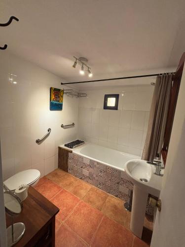 a bathroom with a tub and a toilet and a sink at Casa Cerca del cielo in El Chorro