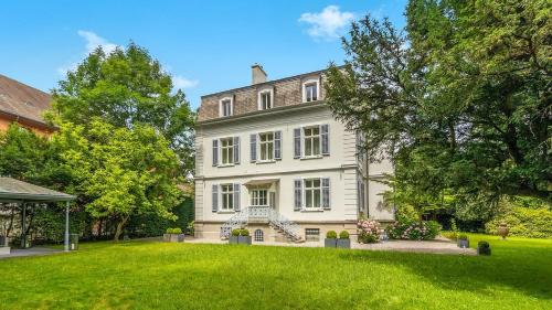 a large white house with a green yard at Private Villa in Central Zurich in Zürich