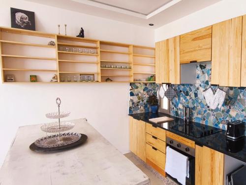 Una cocina con armarios de madera y una mesa. en Live & Work in Essaouira, en Essaouira