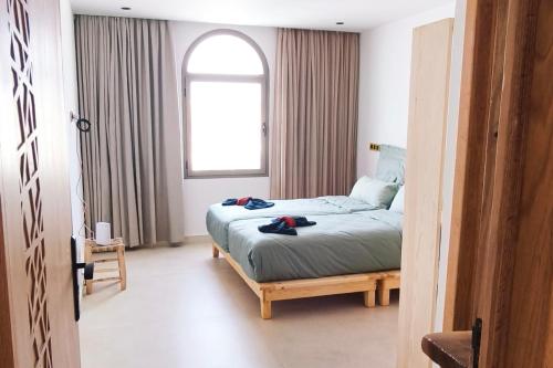Un dormitorio con una cama y una ventana. en Live & Work in Essaouira, en Essaouira