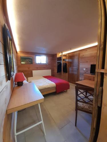 a small bedroom with a bed and a table at Kuhstall Suite mit Bad in Nenzlingen