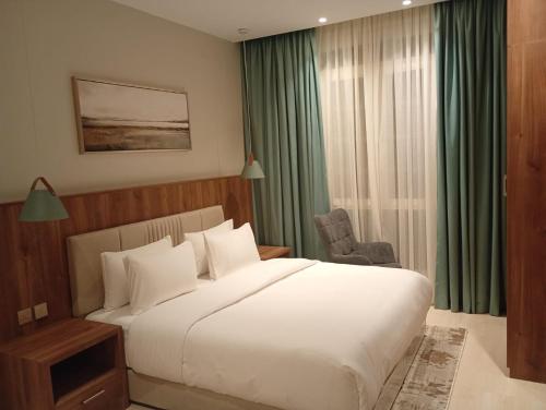 a bedroom with a large white bed and a chair at Samt Residence - LUX apartments in Quai