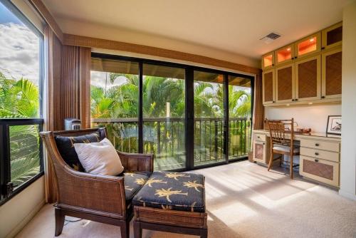 a living room with a chair and a desk and windows at Wailea Ekahi 17D · WEK 17D Wailea Retreat w Ocean View Pool AC in Wailea