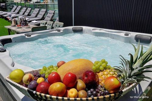 a bowl of fruit in a tub of water at אחוזת אורפז - וילה מדהימה עם בריכה פרטית מחוממת וג'קוזי בזרעית in Zar‘it