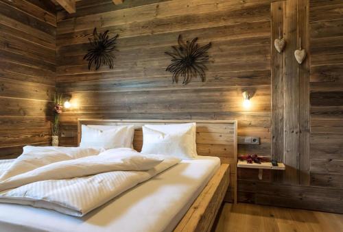 a bed in a room with wooden walls at Sunny Hideaway in Hart im Zillertal
