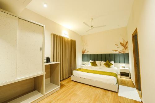 una habitación de hotel con una cama y una ventana grande en M Suites And Hotel, en Kochi