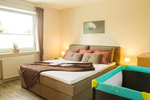 a bedroom with a bed with a large window at Ferienhaus Betty in Rhauderfehn