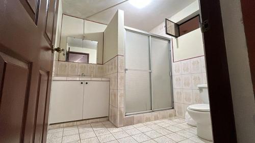 a bathroom with a shower and a toilet and a sink at Casa tipo colonial en las faldas del cerro del baul in Quetzaltenango