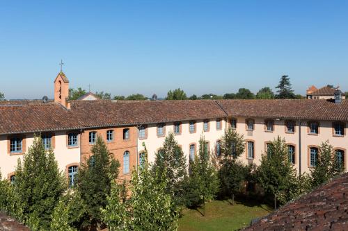 an old building with trees in front of it at Abbaye des Capucins Spa & Resort in Montauban