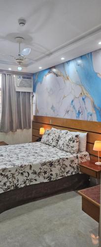 a bedroom with a large bed with a mural on the wall at Dublin Hotel in São Paulo