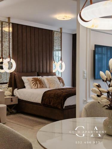 a bedroom with a large bed and a table at Gold Apartment E47 Studio Let's Sea Baltic Park Gąski in Gąski