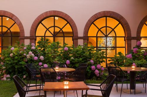 a patio with tables and chairs and flowers at Abbaye des Capucins Spa & Resort in Montauban