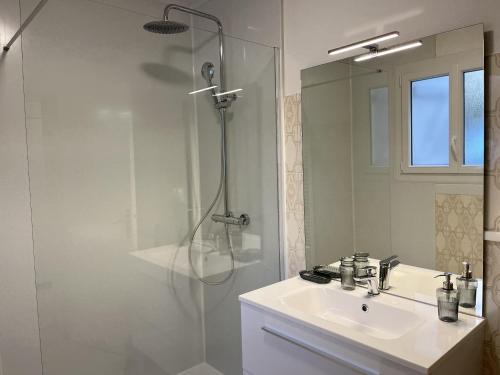 a white bathroom with a shower and a sink at L'Oiselière - Campagne - Proche circuit - 5p in Mulsanne