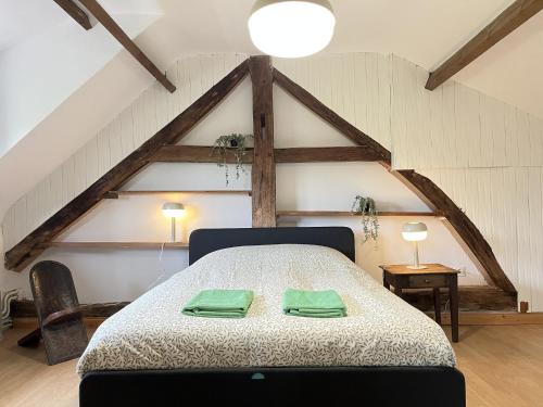 a bedroom with a bed with two green towels on it at L'Oiselière - Campagne - Proche circuit - 5p in Mulsanne