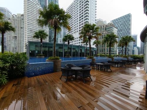 Un vestíbulo de hotel con mesas y palmeras en una ciudad. en The moon light vortex suits kl, en Kuala Lumpur