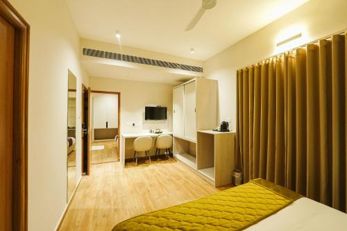 una habitación de hotel con una cama y un baño en M Suites And Hotel, en Kochi