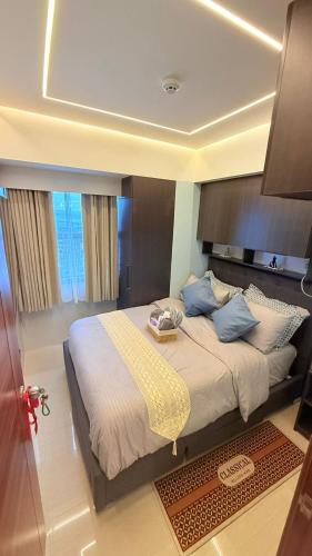 a bedroom with a large bed with blue pillows at LM50L2 horizon101 cebu in Cebu City