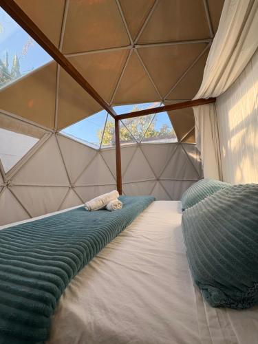 a bed in a triangular room with a window at ADAMA Glamping in Chiclana de la Frontera